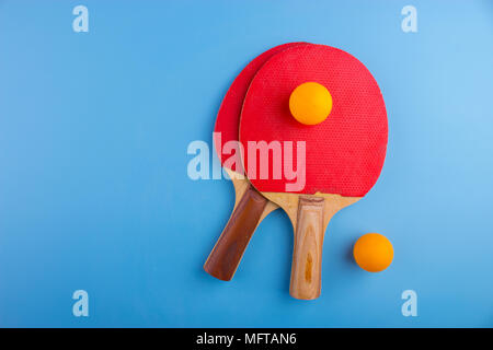 Raquettes et balles de tennis de table sur fond bleu Banque D'Images