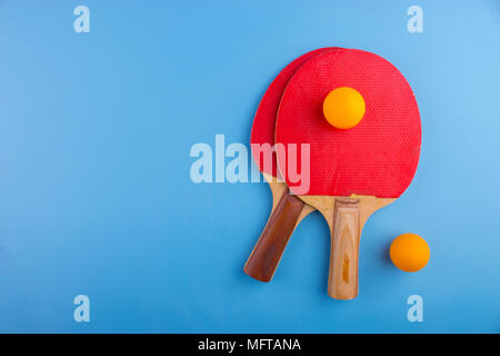 Raquettes et balles de tennis de table sur fond bleu Banque D'Images