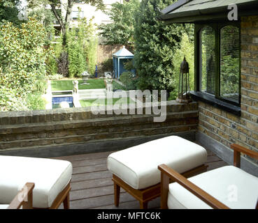 Des fauteuils et tabourets sur le toit-terrasse d'une maison en brique. Banque D'Images