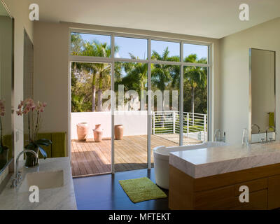 Salle de bains moderne avec porte en verre ouvrant sur balcon terrasse salon Banque D'Images