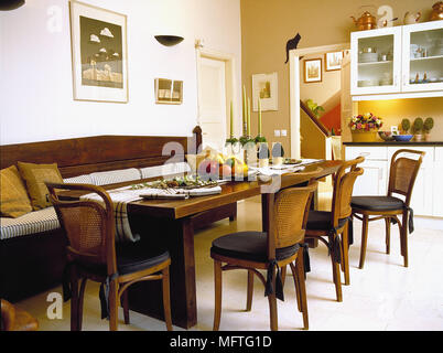 Table et chaises en bois et banquette en salle à manger jaune Banque D'Images