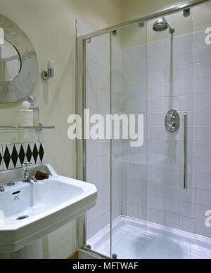 Une salle de bains moderne avec des murs de couleur crème lavabo douche étagère en verre Banque D'Images