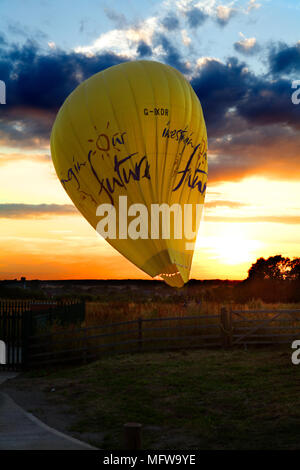 Un ballon à air chaud fait un atterrissage forcé dans un champ Bedfordshire au coucher du soleil Banque D'Images