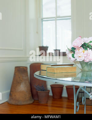 Table en verre avec vase de roses et de livres à prix avec les pots de fleurs Banque D'Images