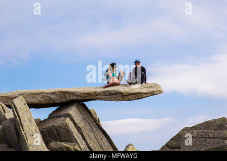 Les randonneurs avec un chien assis sur la roche en porte-à-faux sur Glyder Fach Mountain dans le parc national de Snowdonia. Pays de Galles, Royaume-Uni, Angleterre Banque D'Images