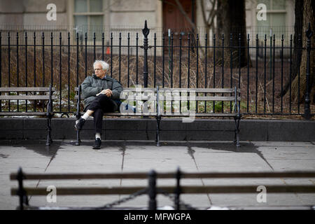 Manhattan à New York City, monsieur plus âgé se reposant sur un banc de la rue du parc à l'Hôtel de Ville Banque D'Images