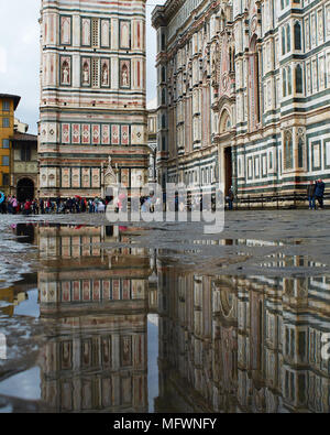 Le duomo et le campanile se reflètent dans une flaque d'eau après une averse Banque D'Images