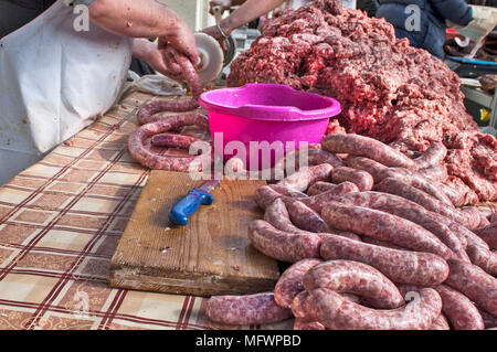 Le Boucher fait des saucisses en plein air de façon traditionnelle. Banque D'Images