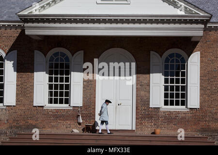 Un homme en costume colonial traditionnel, promenades en face du palais de portes le duc de Gloucester Street, dans la ville coloniale de Williamsburg Banque D'Images