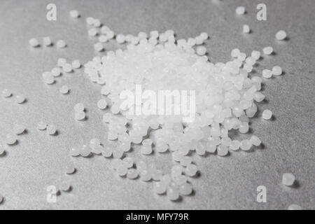 Granulés de polypropylène sur le fond gris. Banque D'Images