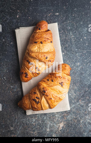 Croissants au chocolat avec des miettes sur la table de cuisine. Vue d'en haut. Banque D'Images