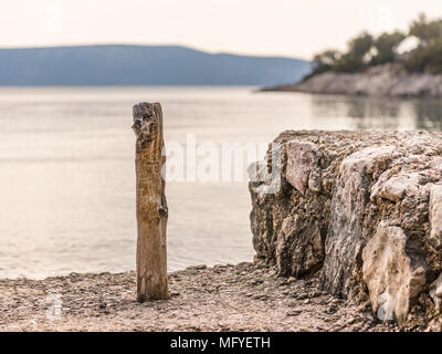 Petit poteau en bois pour l'amarrage des bateaux dans une crique en Croatie (île de Cres) Banque D'Images