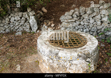 Un ancien puits et mur de pierre dans une forêt en Opatija (Croatie) Banque D'Images