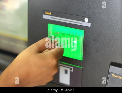 Personne à l'aide d'un guichet automatique. Image de la part de la personne l'insertion d'une carte de débit bancaire pour retirer de l'argent ou la souscription d'une carte bancaire. Banque D'Images