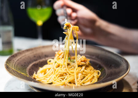 Young woman is holding fourche avec pâtes aux fruits de mer. Banque D'Images