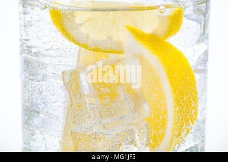 La glace, les tranches de citron et d'eau claire dans un verre. Banque D'Images