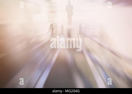 Motion Image floue de l'Homme debout en face de l'Escalator. Banque D'Images
