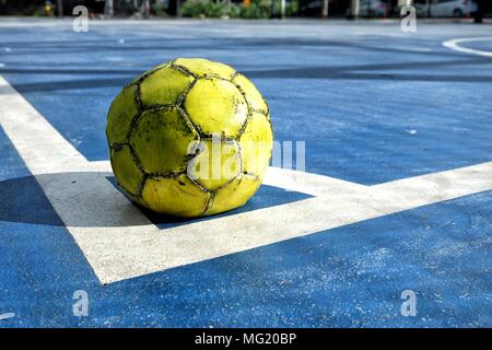 Ancien Ballon futsal jaune sur fond bleu. Banque D'Images