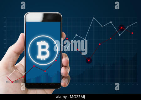 Hand holding mobile smartphone avec B symbole de Bitcoin, les services bancaires sur internet et de bloquer la chaîne sur le fond d'écran graphique et sensibilisation Banque D'Images