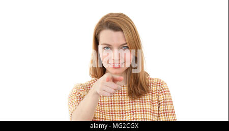 Une jeune femme attrayante un doigt à l'points caméra et sourires - libre - écran blanc studio Banque D'Images