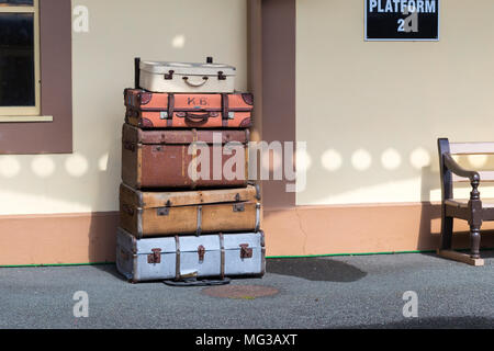 Vintage assurance valises empilées sur la plateforme de la gare de train Banque D'Images