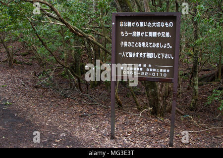 Un signe indiquant aux personnes potentiellement suicidaires de « penser à leurs familles » aux frontières de la forêt d'Aokigahara, connue sous le nom de forêt de suicide, près du Mont Fuji, Yamanashi, Japon Banque D'Images