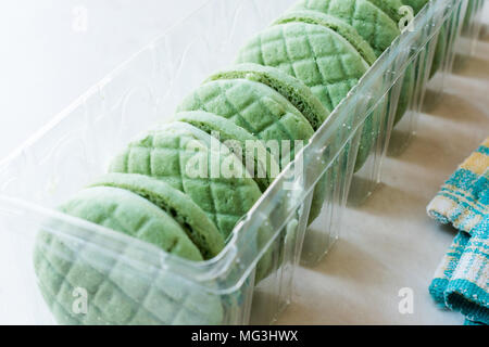 Lime ronde vert rempli de crème Cookies / Macarons dans un contenant de plastique. Apéritif bio Banque D'Images