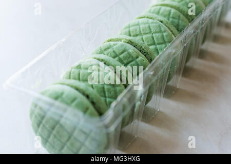 Lime ronde vert rempli de crème Cookies / Macarons dans un contenant de plastique. Apéritif bio Banque D'Images