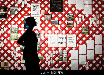 Yorkshire Sculpture Park (YSP) employé Kerry Chase est silhouetté contre un mur en treillis de photos et de mots à l'YSP dévoilement de leur nouveau terrain d'exposition à l'YSP à West Bretton, West Yorkshire. Banque D'Images