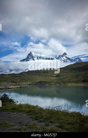 Les montagnes de Torres del Paine au milieu des nuages. Plan d'eau et de prairies de marais dans l'avant-garde. Panorama. Banque D'Images