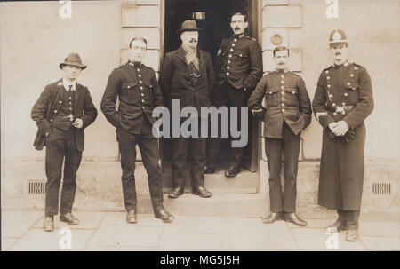 Véritable Carte postale photographique de policiers britanniques debout à l'entrée d'un poste de police Banque D'Images