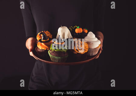 Personne tenant cupcakes halloween Banque D'Images