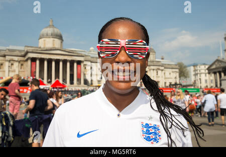 Une femme avec une Angleterre shirt et lunettes Union Jack se joint à Trafalgar Square pour "La Fête de la St George' pour marquer le Jour de rue George. Banque D'Images