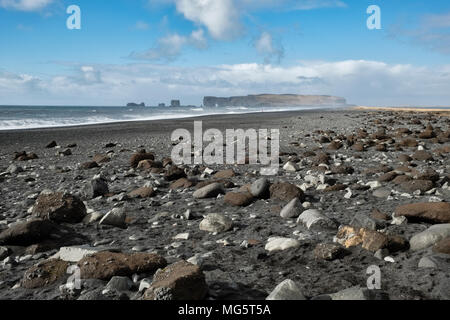 Près de Reynisfjara qui jouit, Vík, Sud de l'Islande. La plage de sable noir est une célèbre attraction touristique. La péninsule de Dyrhólaey arch rock est à l'horizon Banque D'Images
