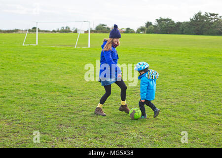 Une mère jouant au football avec son fils Banque D'Images