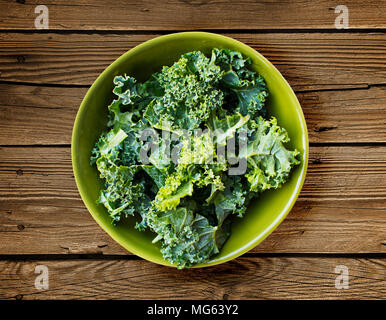 Kale frais dans un bol vert sur une surface en bois Banque D'Images