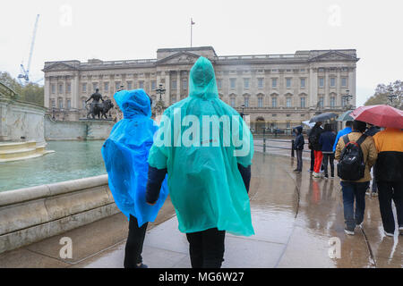 London UK. 27 avril 2018. Les touristes à l'abri de la pluie à l'extérieur de Buckingham Palace, sur un jour de pluie à Londres Banque D'Images