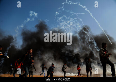 La bande de Gaza. Apr 27, 2018. Des manifestants palestiniens exécuter pour enlever le couvercle de gaz lacrymogène tiré par des soldats israéliens lors d'affrontements à l'Est de la ville de Gaza, le 27 avril 2018. Credit : Stringer/Xinhua/Alamy Live News Banque D'Images