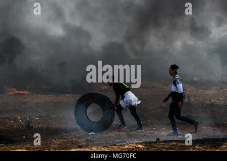 La bande de Gaza. Apr 27, 2018. Des manifestants palestiniens déplacer un pneu à brûler au cours d'affrontements avec les troupes israéliennes au cours d'affrontements à l'Est de la ville de Gaza, le 27 avril 2018. Credit : Stringer/Xinhua/Alamy Live News Banque D'Images