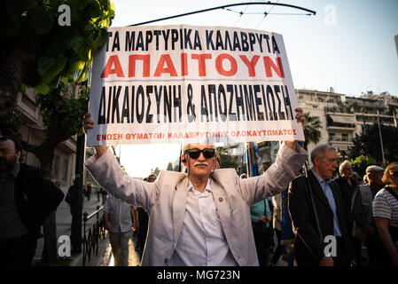 Athènes, Grèce. Apr 27, 2018. Un manifestant vu holding a placard pendant la manifestation.Premier rassemblement au monument du Soldat inconnu, la progression s'est faite jusqu'à l'Ambassade pour protester pour la compensation de la Deuxième Guerre mondiale, de l'Allemagne comme plusieurs le massacre perpétué par les soldats allemands en 1943 ont été commis. Credit : Vangelis/Evangeliou SOPA Images/ZUMA/Alamy Fil Live News Banque D'Images