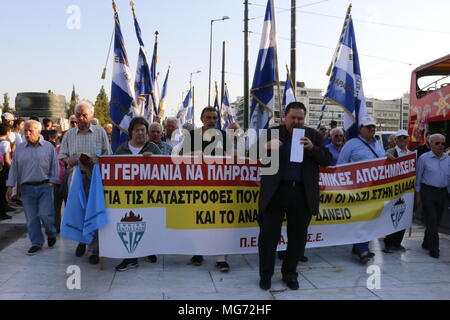 Vu les manifestants holding banner et d'un drapeau pendant la démonstration. Mot grec War 2 Les membres font preuve de résistance à Athènes exigeant de l'Allemagne à verser une indemnité de guerre de l'Allemagne nazie vers la Grèce. Banque D'Images