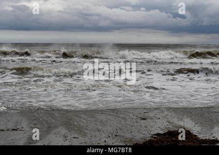 Par plage sous les nuages très sombres Banque D'Images