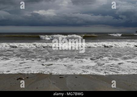 Par plage sous les nuages très sombres Banque D'Images