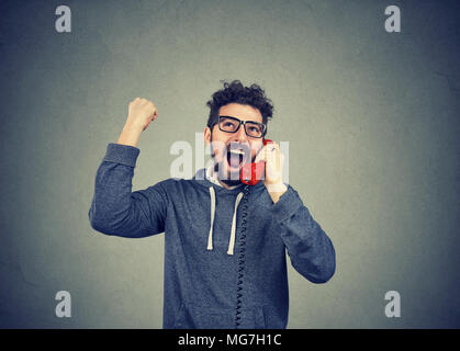 Jeune homme hipster recevant une excellente nouvelle par téléphone se sentir excité Banque D'Images