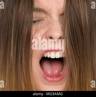 Jeune femme criant avec la bouche ouverte. Banque D'Images