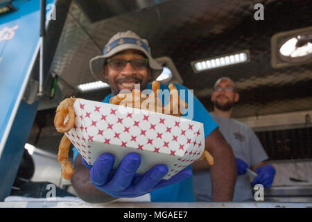 Afro-américain propriétaire de petite entreprise dans son camion alimentaire avec un panier plein d'oignon frit Banque D'Images