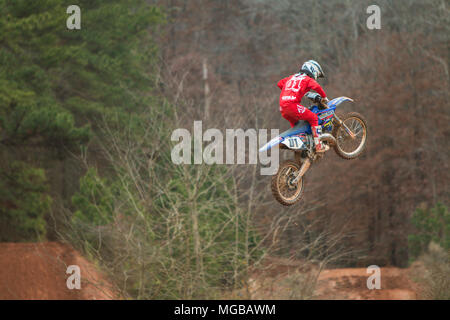 Un cavalier est sur l'air d'un hiver gris jour après avoir traversé un saut dans une course de motocross à l'Scrubndirt La voie le 3 décembre 2016 à Monroe, GA. Banque D'Images