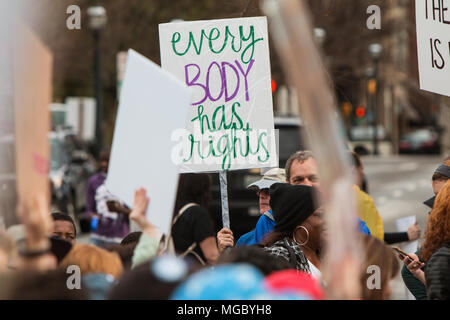 Un homme nous tend un panneau qui dit "chaque corps a l'homme" pendant qu'il marche dans la Marche pour les femmes le 21 janvier 2016 à Atlanta, GA. Banque D'Images