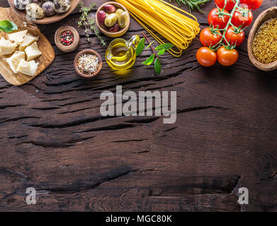 Différents types de pâtes alimentaires dans des cuillères en bois sur la table. Vue d'en haut. Banque D'Images
