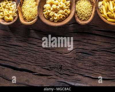 Différents types de pâtes en bols en bois sur la table. Vue d'en haut. Banque D'Images
